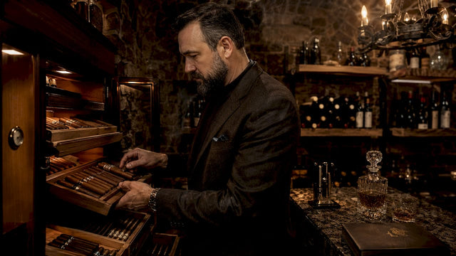 Man organizing cigars in multi-level humidor cabinet