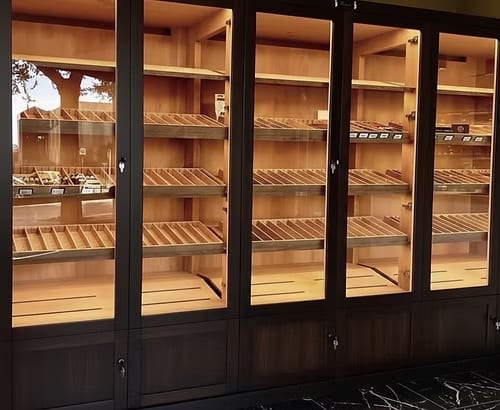 Glass-front retail cigar showcase wall with illuminated cedar shelving